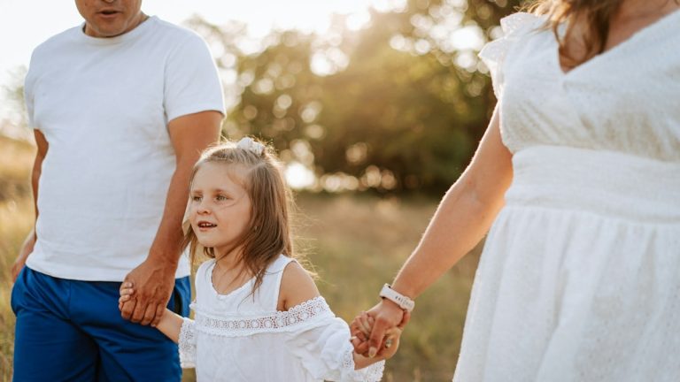 A man and a woman holding hands with a little girl