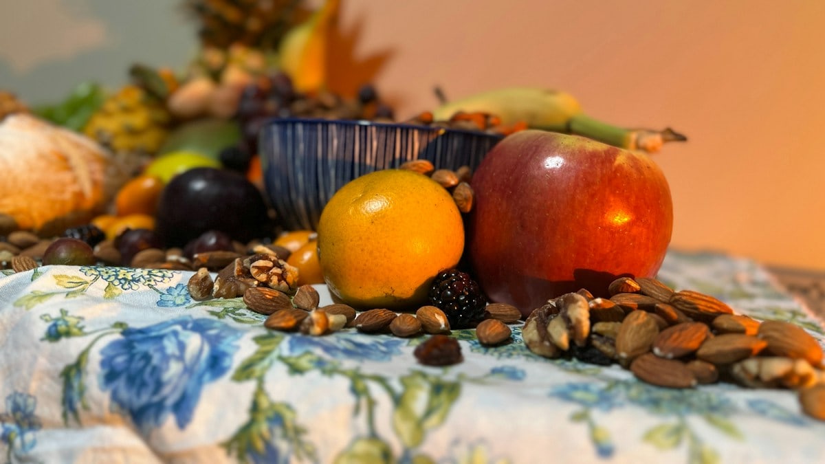 a table topped with a bowl of fruit and nuts